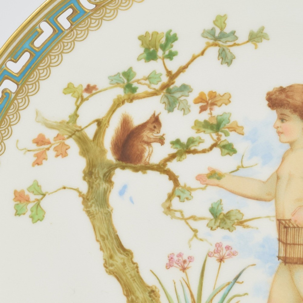 An antique round Minton porcelain cabinet plate featuring a reticulated gilt rim with turquoise trim and a hand-painted central illustration of a winged fairy near a squirrel in an oak tree. View VI