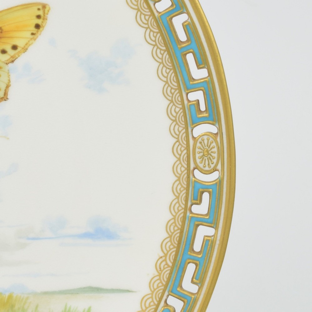 An antique round Minton porcelain cabinet plate featuring a reticulated gilt rim with turquoise trim and a hand-painted central illustration of a winged fairy near a squirrel in an oak tree. View X
