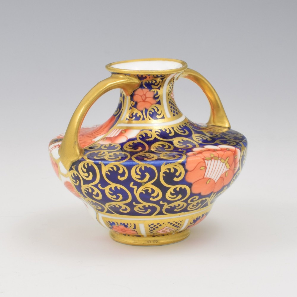 An Edwardian Royal Crown Derby miniature twin-handled porcelain vase decorated with an Imari floral pattern in cobalt blue, iron red, and gilt. View II