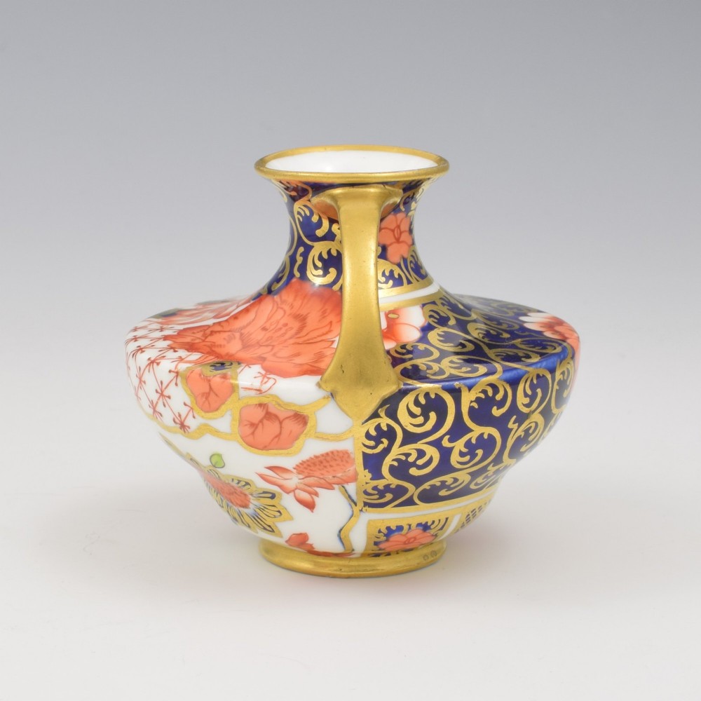 An Edwardian Royal Crown Derby miniature twin-handled porcelain vase decorated with an Imari floral pattern in cobalt blue, iron red, and gilt. View III