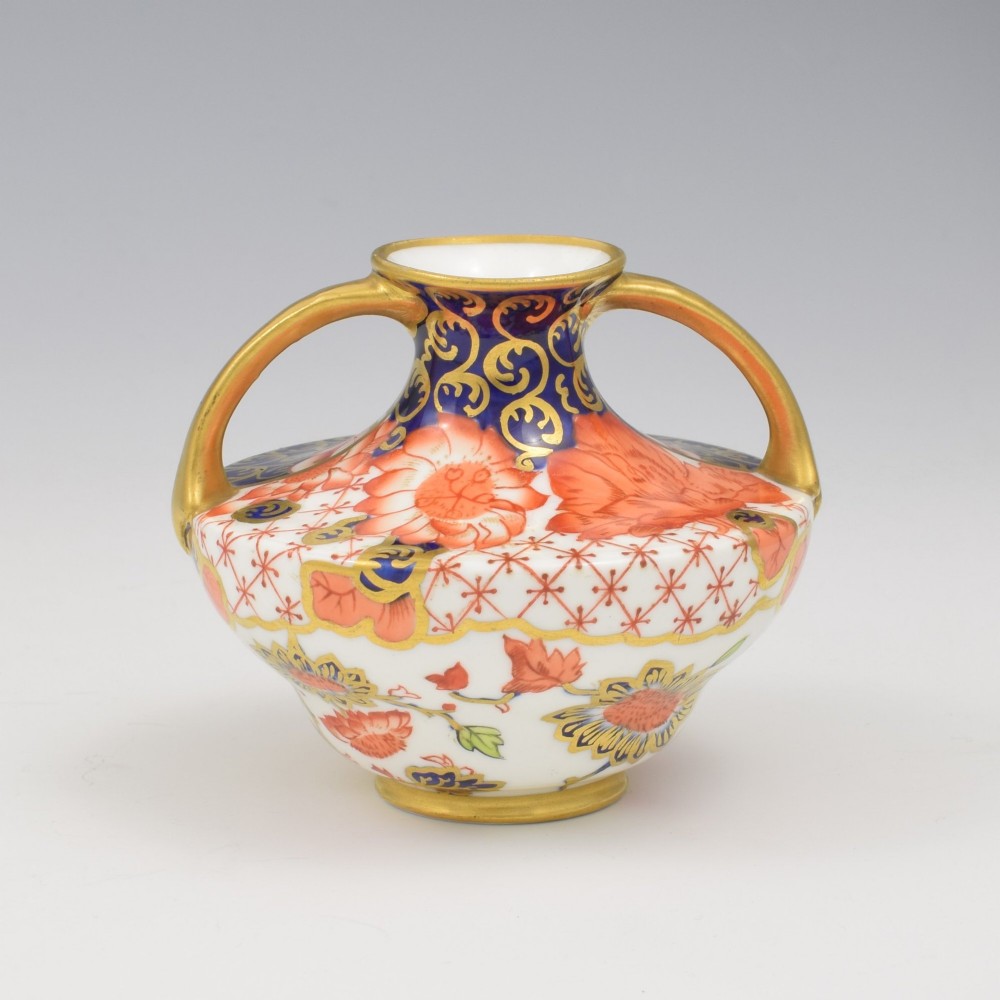 An Edwardian Royal Crown Derby miniature twin-handled porcelain vase decorated with an Imari floral pattern in cobalt blue, iron red, and gilt. View V