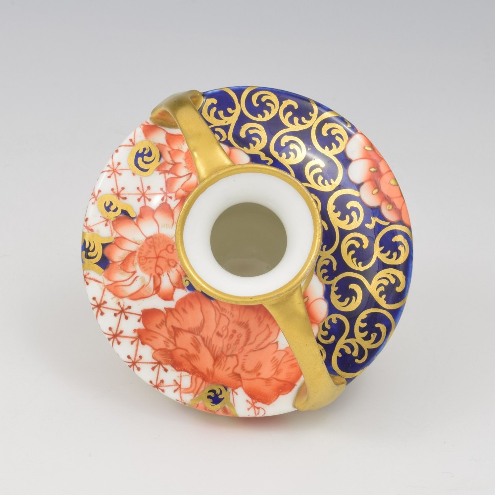 An Edwardian Royal Crown Derby miniature twin-handled porcelain vase decorated with an Imari floral pattern in cobalt blue, iron red, and gilt. View X