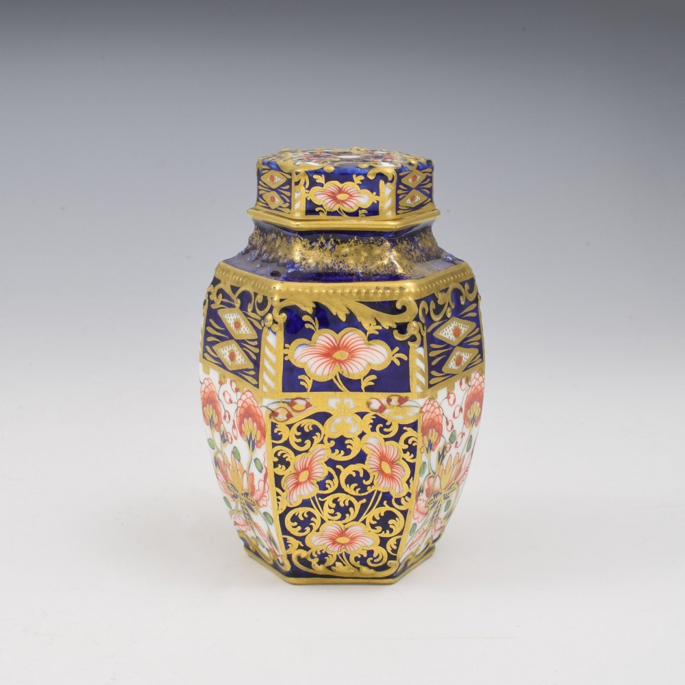 A Victorian hexagonal porcelain tea canister decorated in cobalt blue, iron red, and gilt hand-painted floral motifs with a fitted lid.