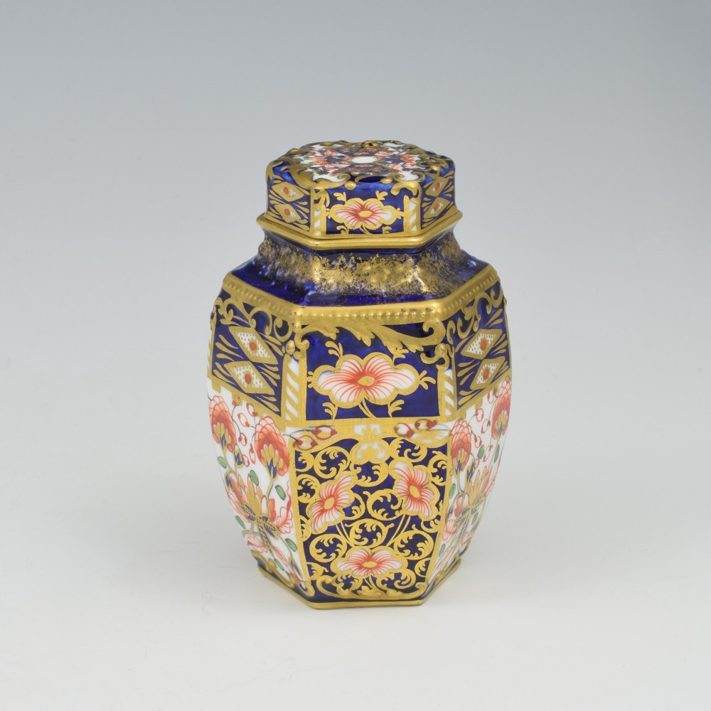 A Victorian hexagonal porcelain tea canister decorated in cobalt blue, iron red, and gilt hand-painted floral motifs with a fitted lid. View V