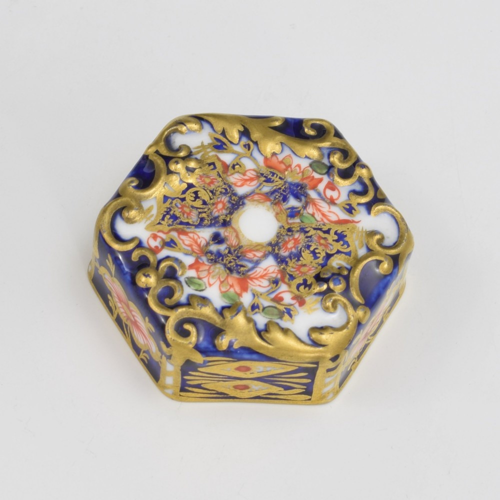 A Victorian hexagonal porcelain tea canister decorated in cobalt blue, iron red, and gilt hand-painted floral motifs with a fitted lid. View X