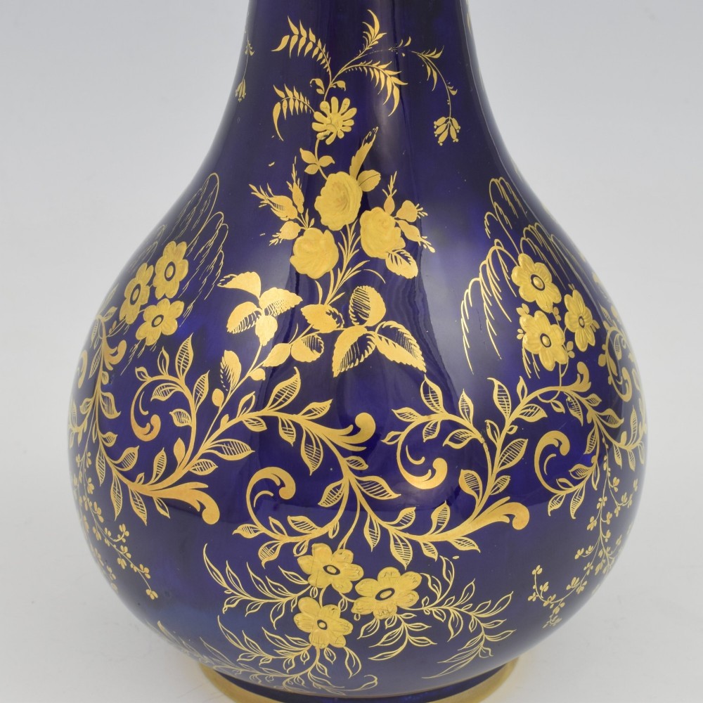 A cobalt blue porcelain bottle vase decorated with elaborate gold floral gilding and fitted with a matching rounded stopper. View VIII
