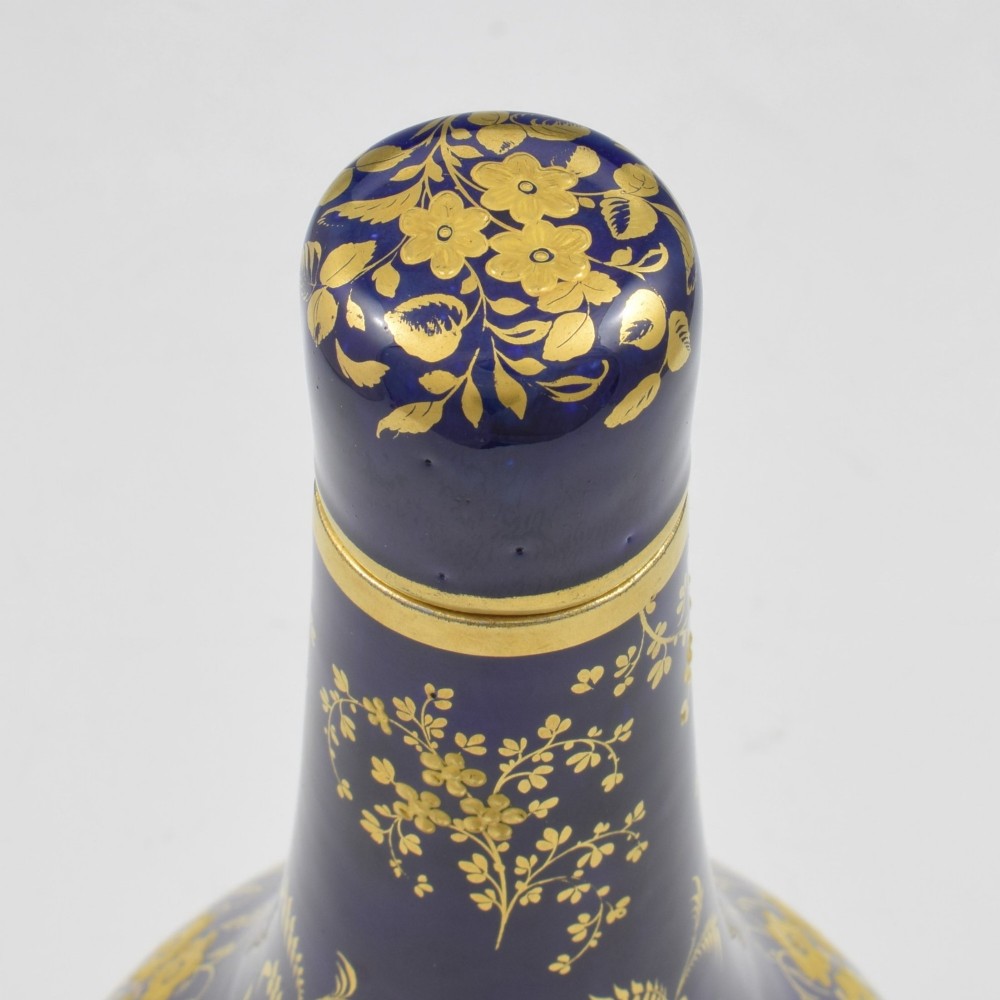 A cobalt blue porcelain bottle vase decorated with elaborate gold floral gilding and fitted with a matching rounded stopper. View XI