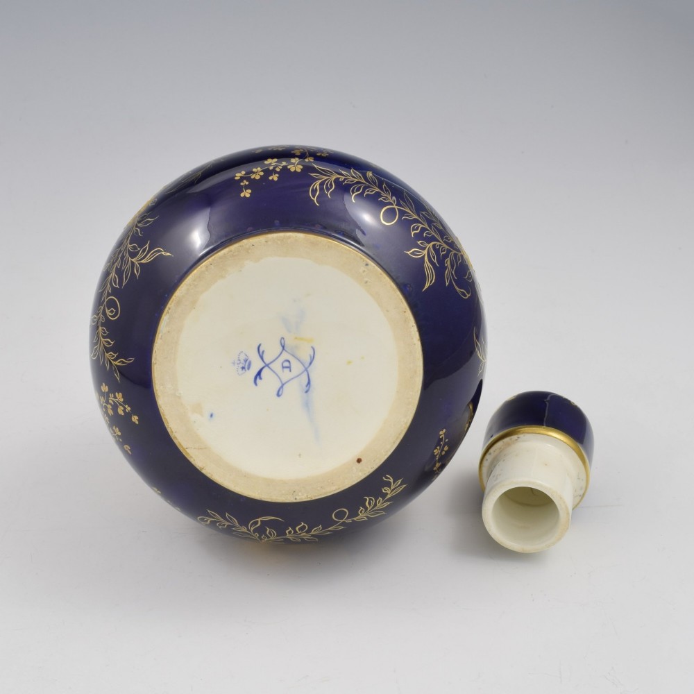 A cobalt blue porcelain bottle vase decorated with elaborate gold floral gilding and fitted with a matching rounded stopper. View XIII