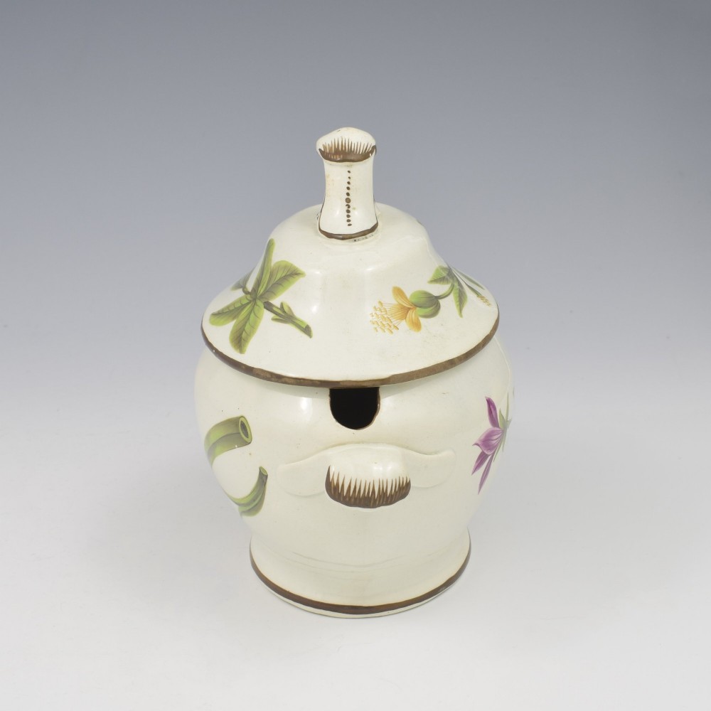 A Georgian cream pearlware lidded sauce tureen hand painted with botanical flowers and featuring scroll handles and a scroll finial. View III