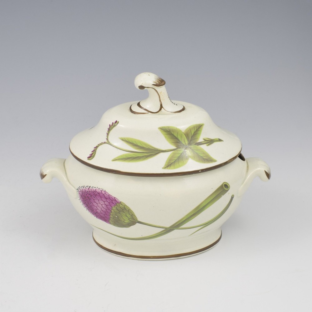 A Georgian cream pearlware lidded sauce tureen hand painted with botanical flowers and featuring scroll handles and a scroll finial. View V