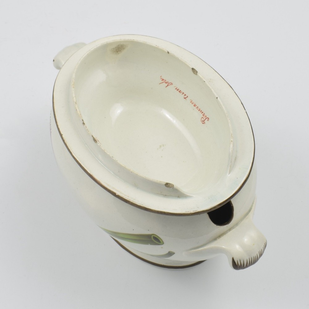 A Georgian cream pearlware lidded sauce tureen hand painted with botanical flowers and featuring scroll handles and a scroll finial. View XIV
