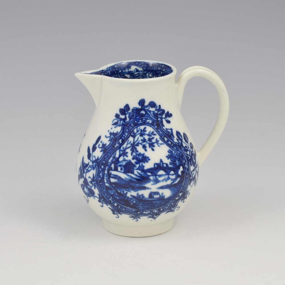 A Georgian blue and white soft-paste porcelain cream jug decorated with an underglaze landscape print in a cartouche frame. View III
