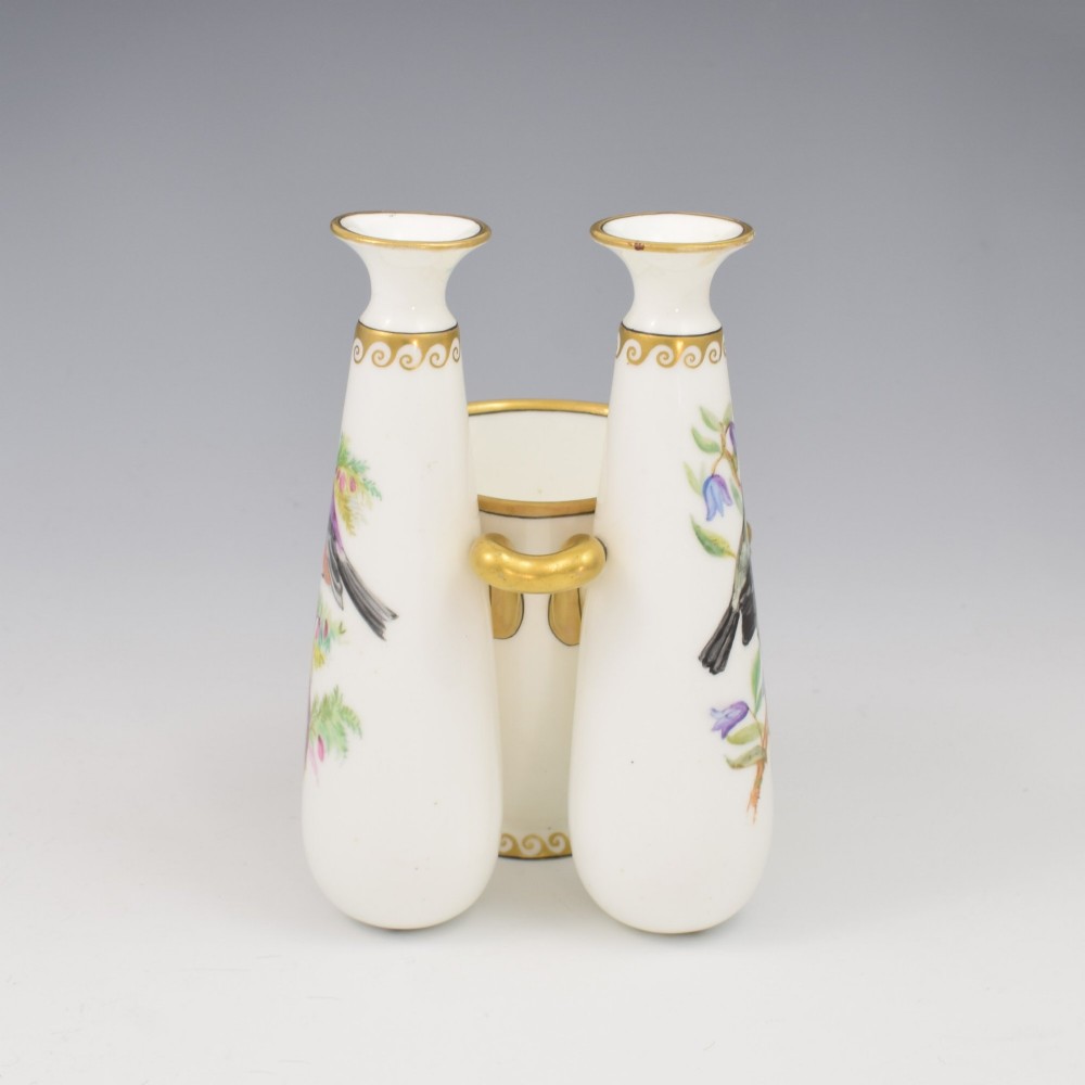 A Victorian white porcelain triple vase featuring three connected vessels decorated with hand-painted birds and gilt trim. View IV