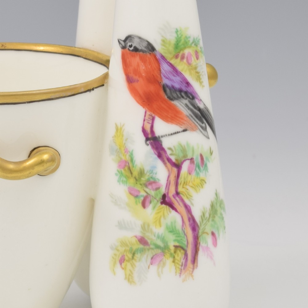 A Victorian white porcelain triple vase featuring three connected vessels decorated with hand-painted birds and gilt trim. View VIII