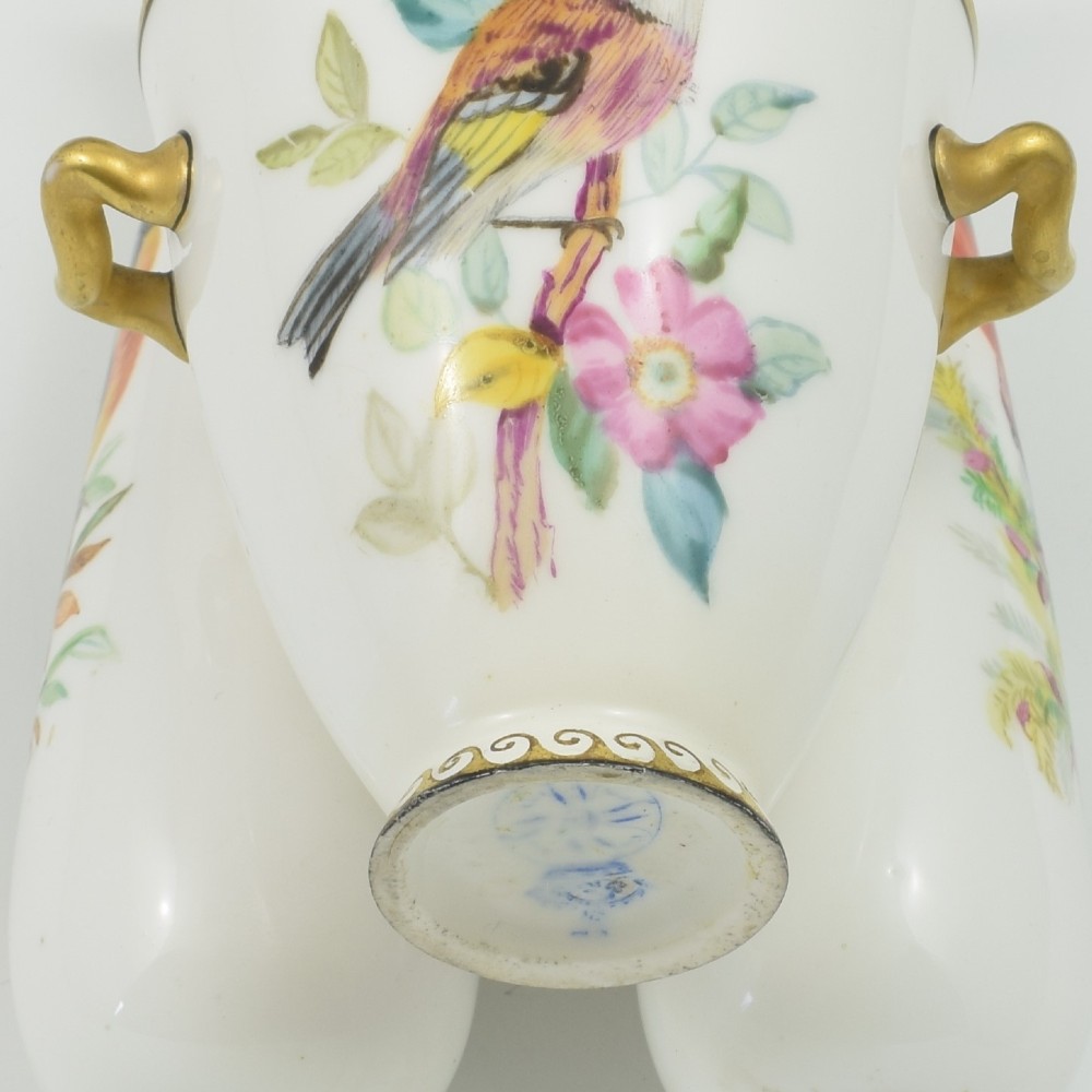 A Victorian white porcelain triple vase featuring three connected vessels decorated with hand-painted birds and gilt trim. View X