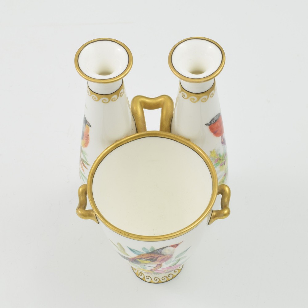 A Victorian white porcelain triple vase featuring three connected vessels decorated with hand-painted birds and gilt trim. View XI
