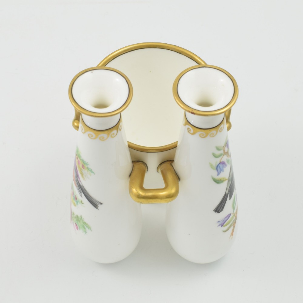 A Victorian white porcelain triple vase featuring three connected vessels decorated with hand-painted birds and gilt trim. View XII