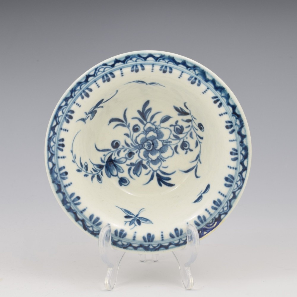 An 18th-century First Period Worcester circular porcelain patty pan featuring underglaze blue peony motifs and a patterned rim.