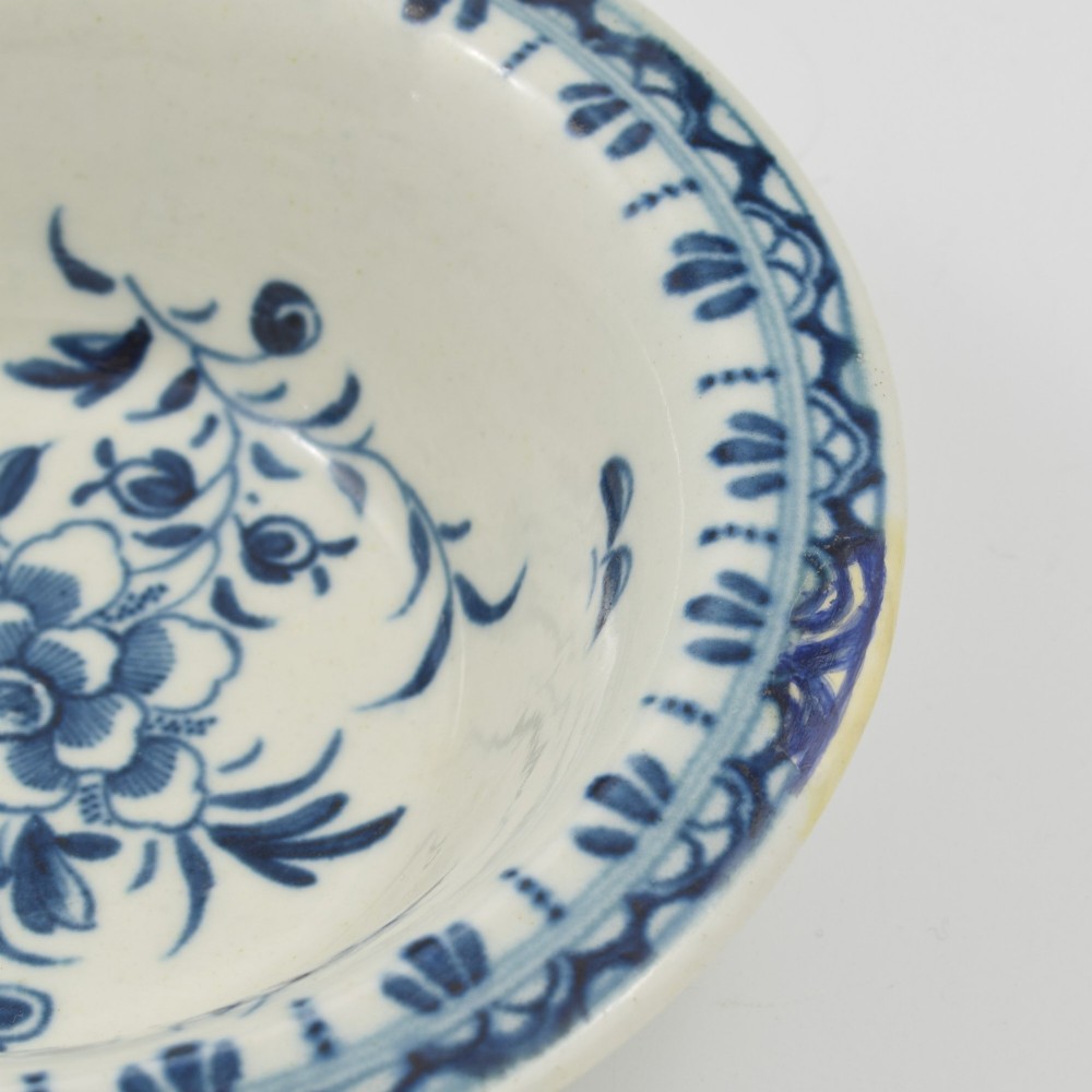 An 18th-century First Period Worcester circular porcelain patty pan featuring underglaze blue peony motifs and a patterned rim. View VII