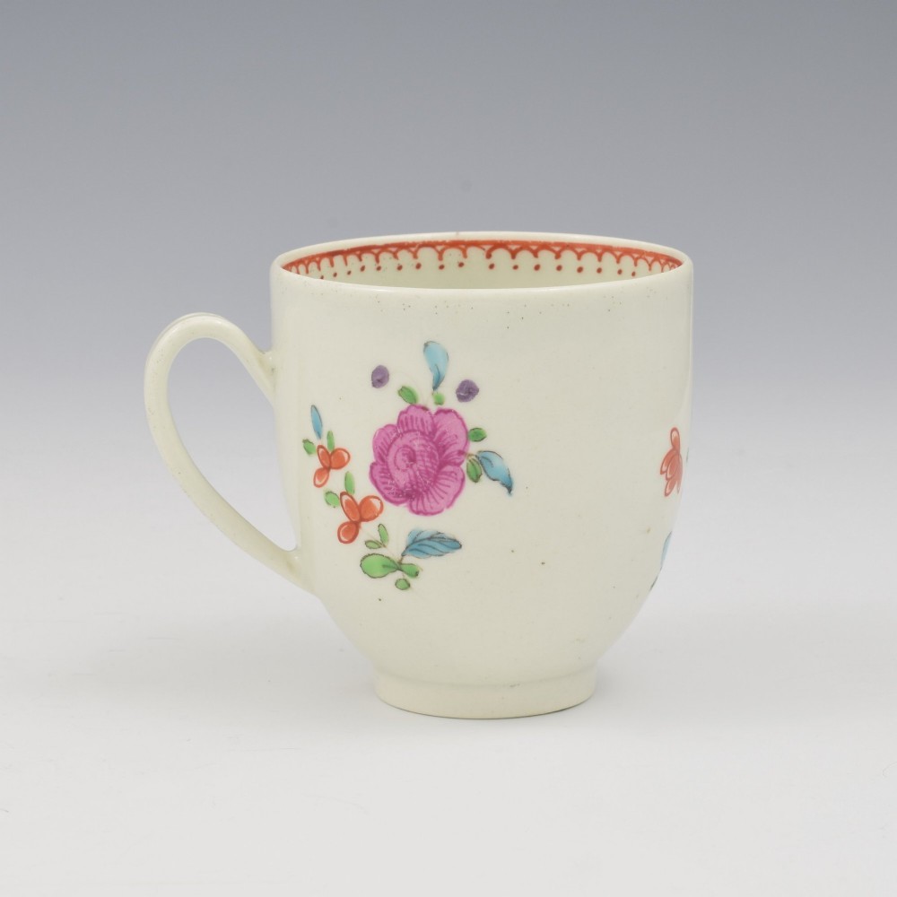 An 18th-century white porcelain coffee cup decorated with hand-painted polychrome floral sprays and an inner red patterned border. View III
