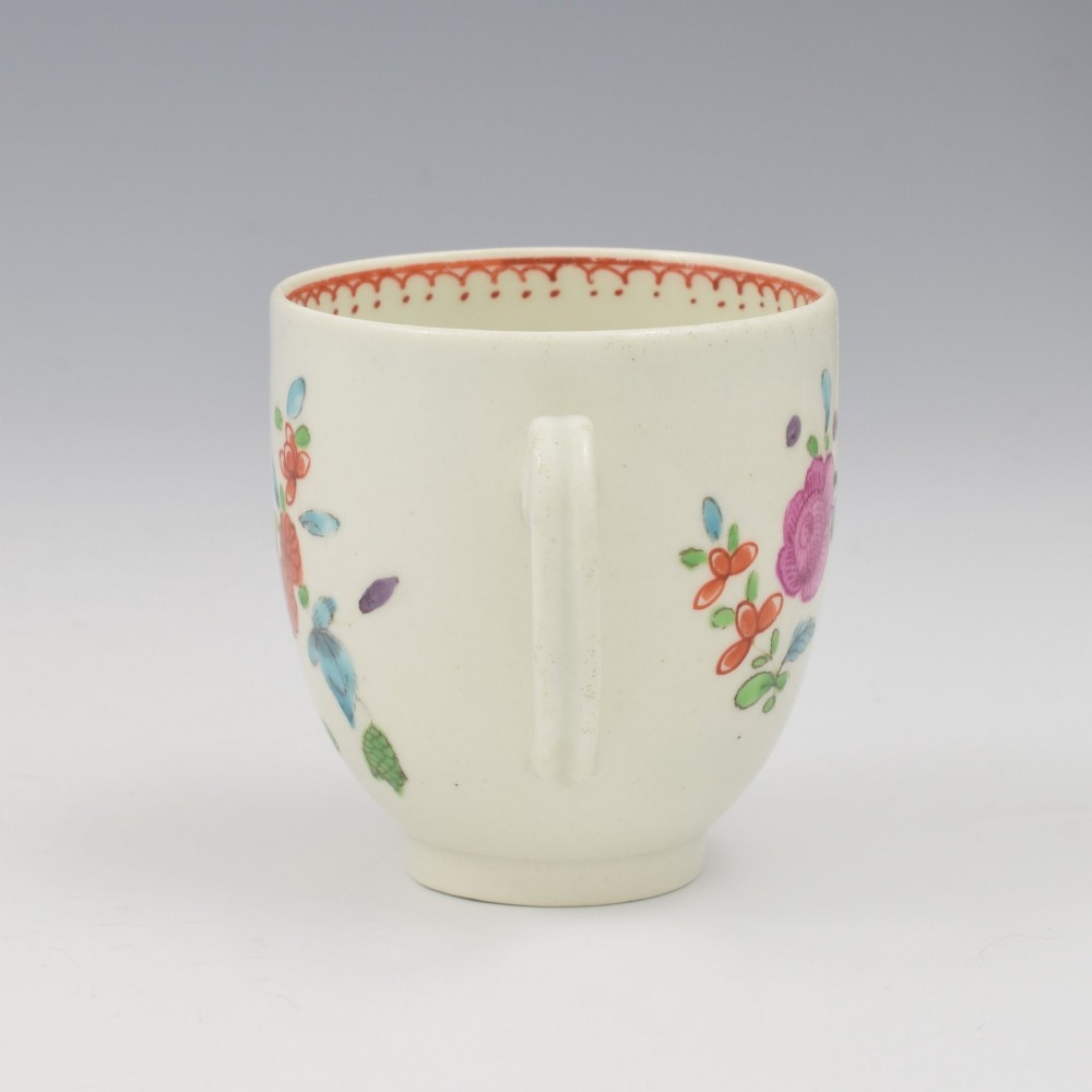 An 18th-century white porcelain coffee cup decorated with hand-painted polychrome floral sprays and an inner red patterned border. View IV
