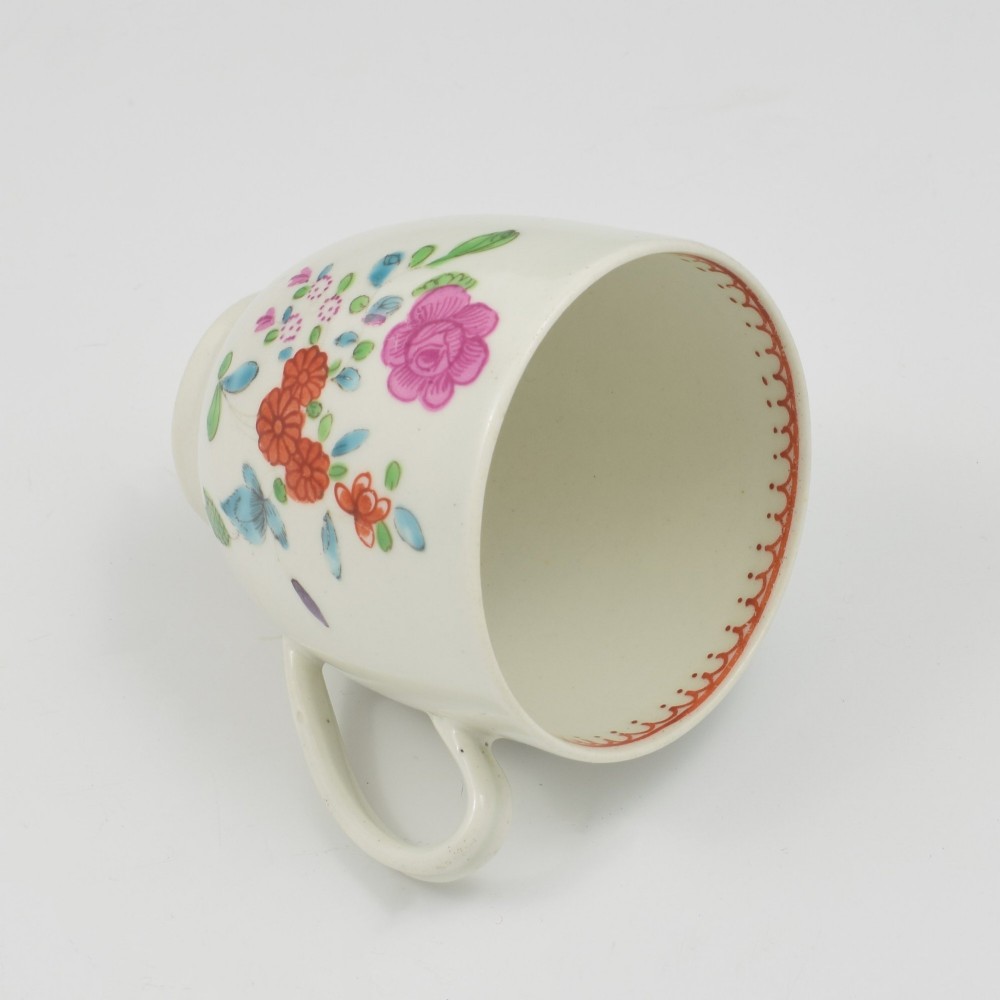 An 18th-century white porcelain coffee cup decorated with hand-painted polychrome floral sprays and an inner red patterned border. View V