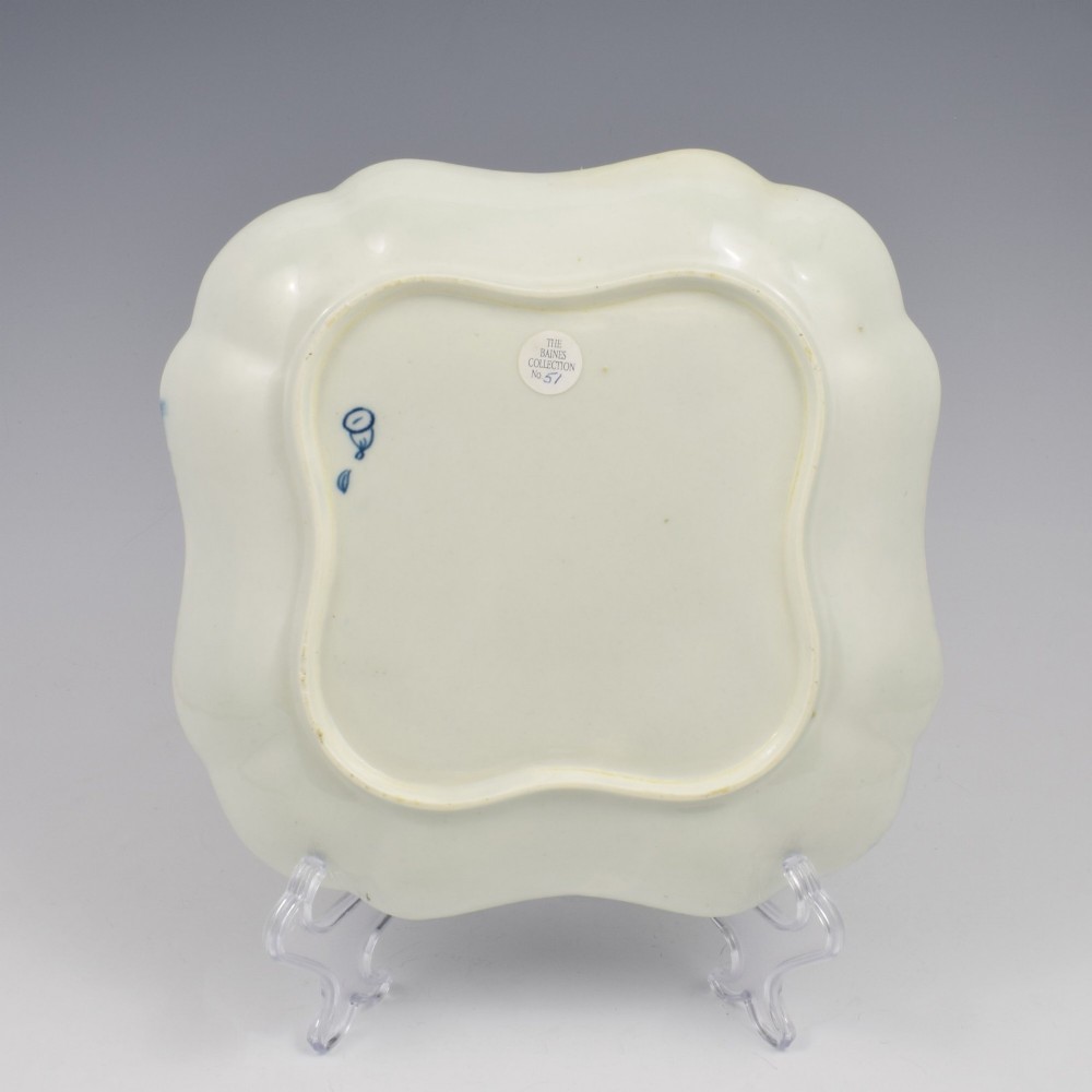 An 18th-century square lobed soft-paste porcelain dish decorated with hand-painted blue floral sprigs and a feathered rim. View III