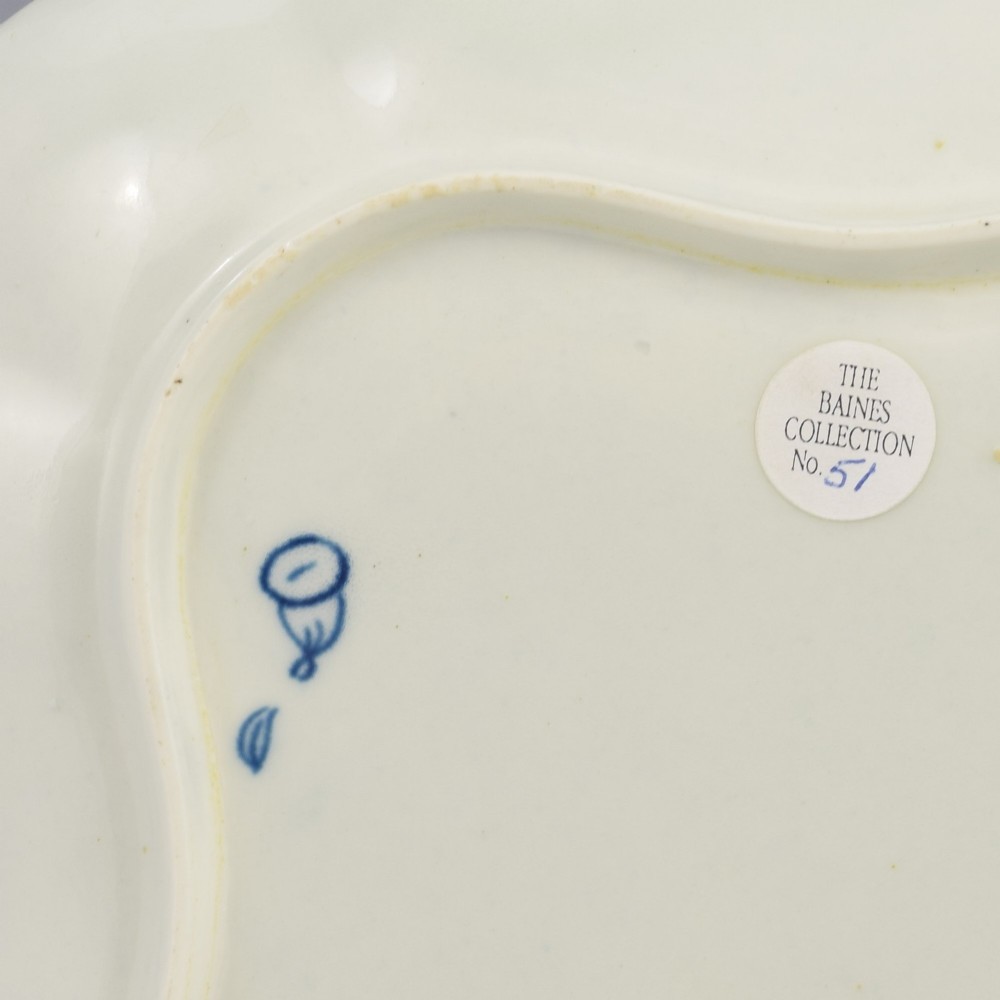 An 18th-century square lobed soft-paste porcelain dish decorated with hand-painted blue floral sprigs and a feathered rim. View IV