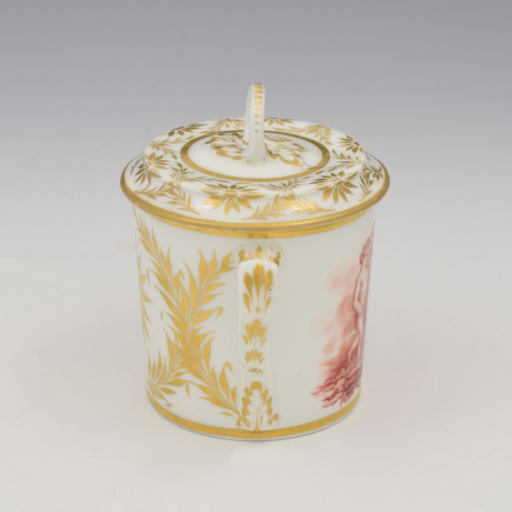 A white Regency period Bloor Derby porcelain chocolate cup featuring twin handles, a fitted lid with a loop finial, hand-painted sepia putti, and gold gilded leaf borders. View III