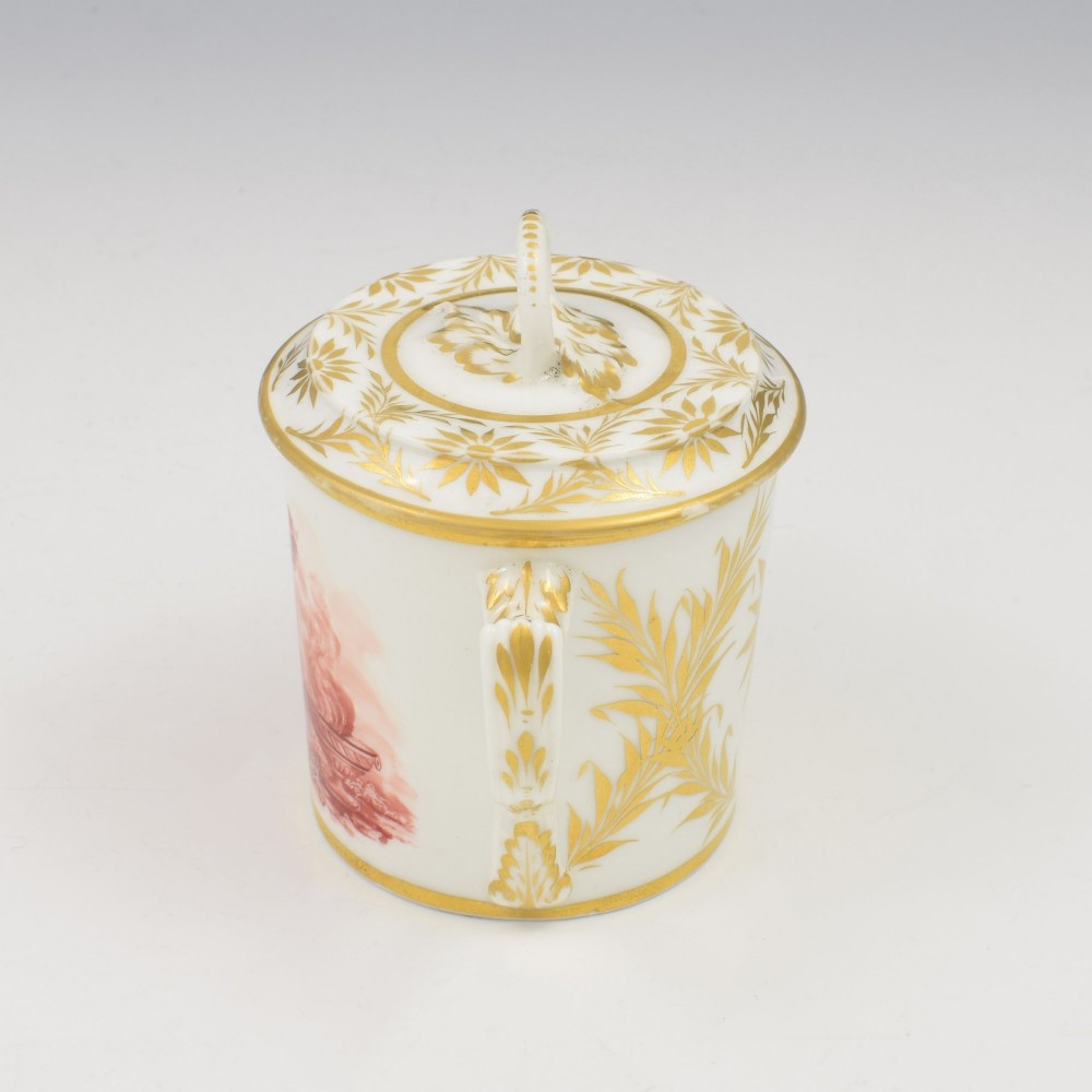 A white Regency period Bloor Derby porcelain chocolate cup featuring twin handles, a fitted lid with a loop finial, hand-painted sepia putti, and gold gilded leaf borders. View VI