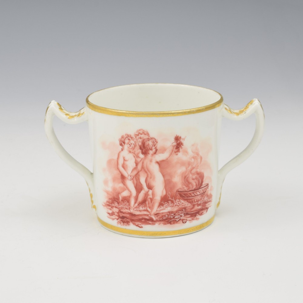 A white Regency period Bloor Derby porcelain chocolate cup featuring twin handles, a fitted lid with a loop finial, hand-painted sepia putti, and gold gilded leaf borders. View VII