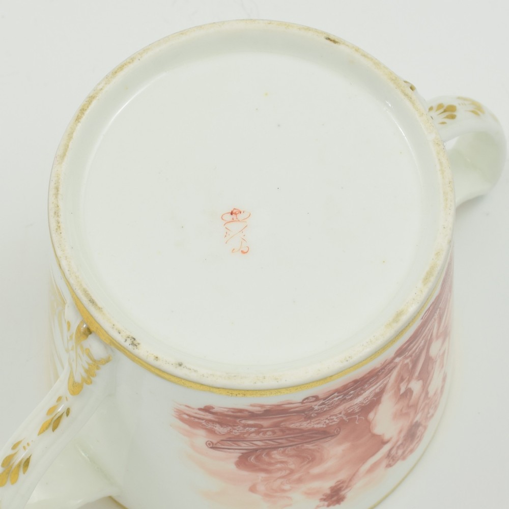 A white Regency period Bloor Derby porcelain chocolate cup featuring twin handles, a fitted lid with a loop finial, hand-painted sepia putti, and gold gilded leaf borders. View XII
