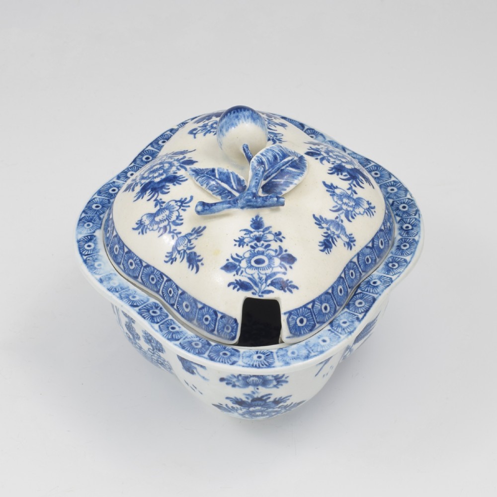 An eighteenth-century Derby soft-paste porcelain sauce tureen and cover featuring a quatrefoil shape, hand-painted blue and white Chinoiserie decoration, and a sculpted fruit handle on the lid. View II