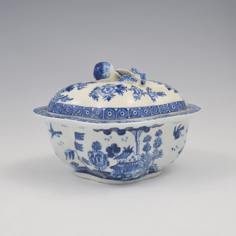 An eighteenth-century Derby soft-paste porcelain sauce tureen and cover featuring a quatrefoil shape, hand-painted blue and white Chinoiserie decoration, and a sculpted fruit handle on the lid. View IV