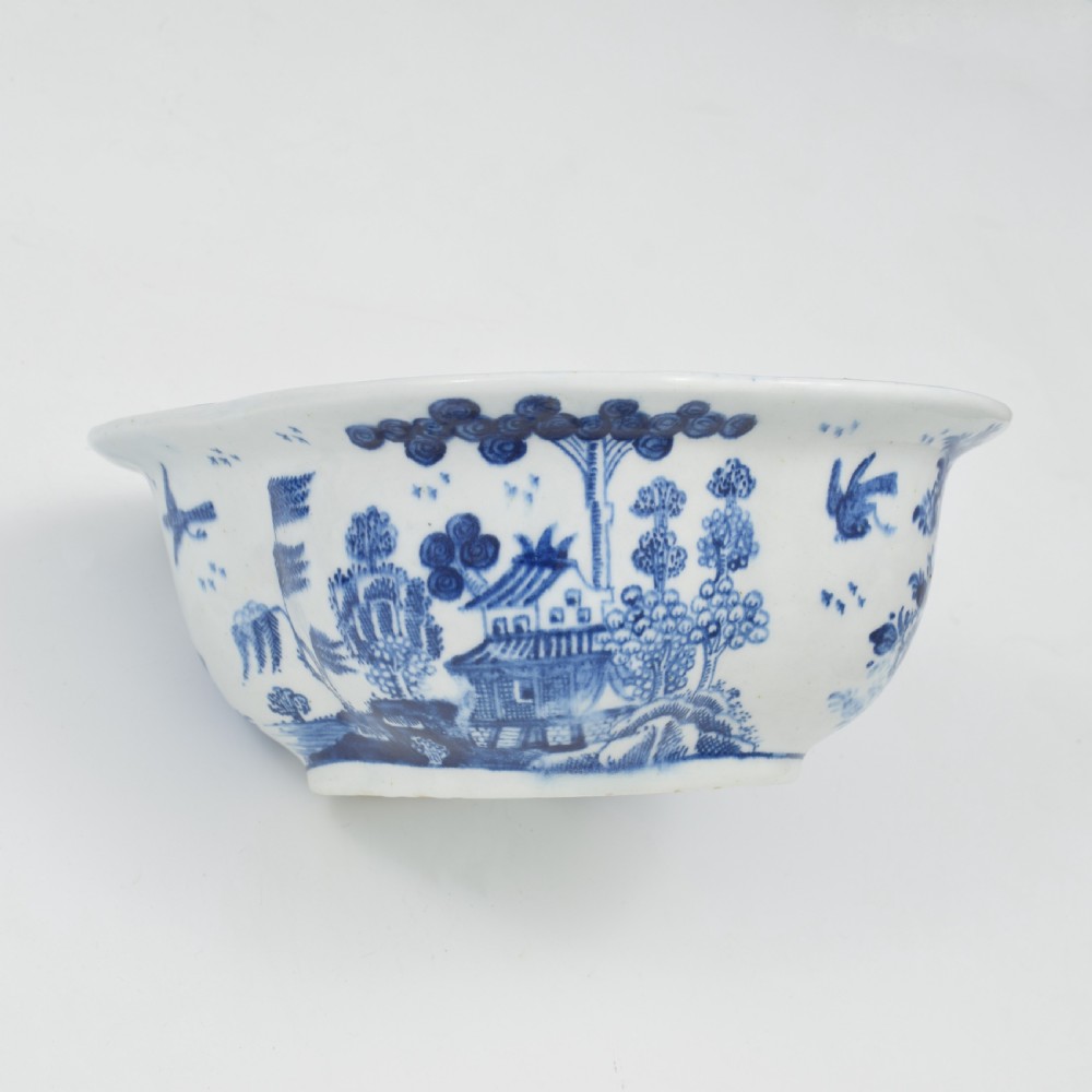 An eighteenth-century Derby soft-paste porcelain sauce tureen and cover featuring a quatrefoil shape, hand-painted blue and white Chinoiserie decoration, and a sculpted fruit handle on the lid. View X