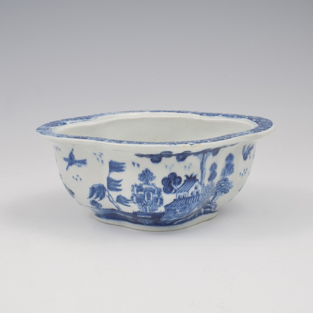 An eighteenth-century Derby soft-paste porcelain sauce tureen and cover featuring a quatrefoil shape, hand-painted blue and white Chinoiserie decoration, and a sculpted fruit handle on the lid. View XIII