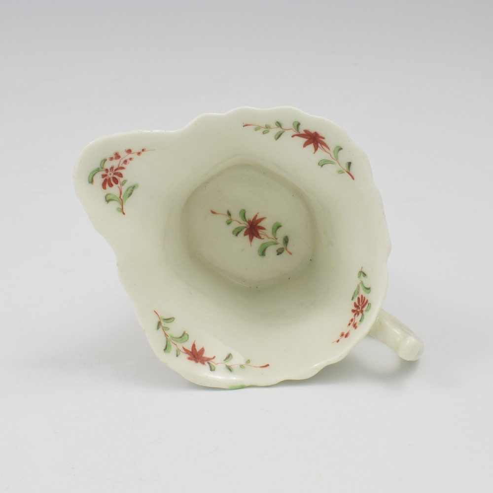 An 18th-century soft-paste porcelain hexagonal sauce boat featuring hand-painted pink floral sprays and a molded scroll handle. View X