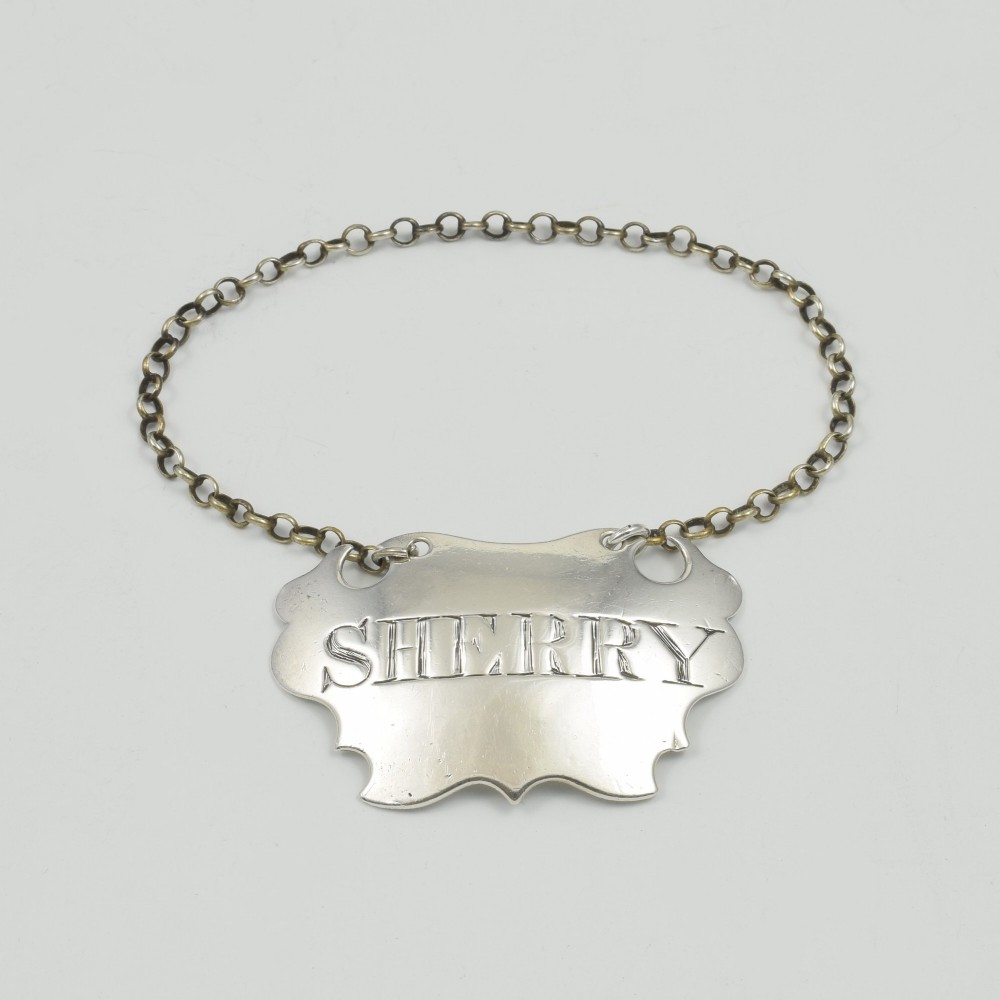 A Georgian sterling silver escutcheon-shaped decanter label engraved with the word SHERRY, featuring a suspension chain. View III