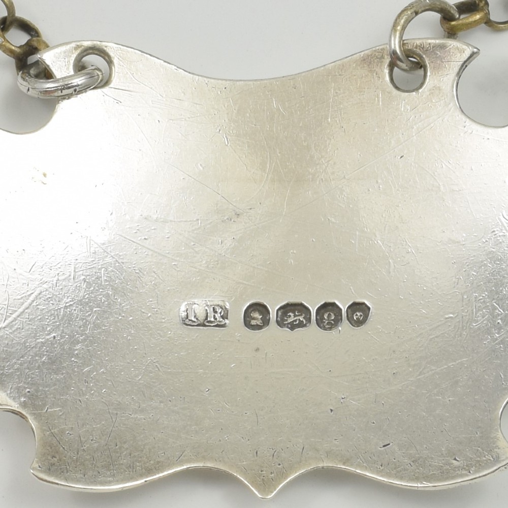 A Georgian sterling silver escutcheon-shaped decanter label engraved with the word SHERRY, featuring a suspension chain. View V