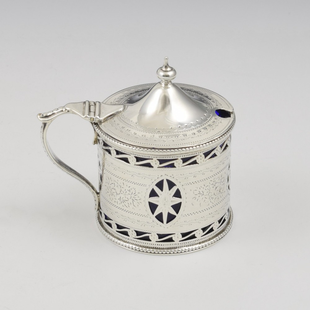 A Victorian silver drum mustard pot with pierced fretwork, bright-cut engraving, a hinged lid, and a cobalt blue glass liner. View II