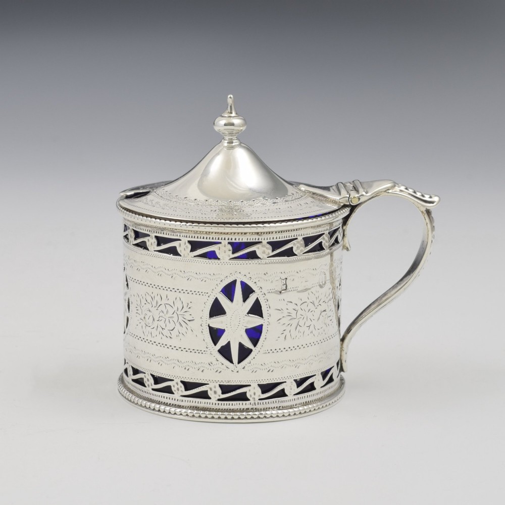 A Victorian silver drum mustard pot with pierced fretwork, bright-cut engraving, a hinged lid, and a cobalt blue glass liner. View IV