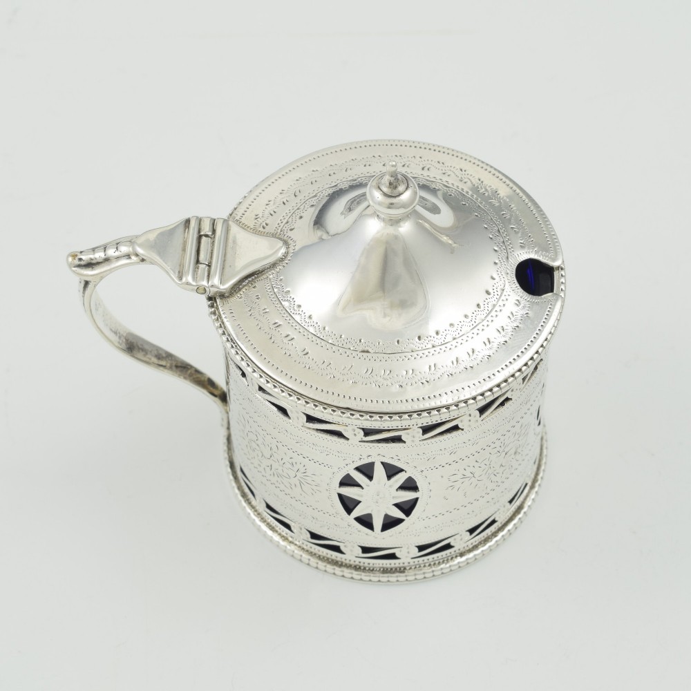 A Victorian silver drum mustard pot with pierced fretwork, bright-cut engraving, a hinged lid, and a cobalt blue glass liner. View VI