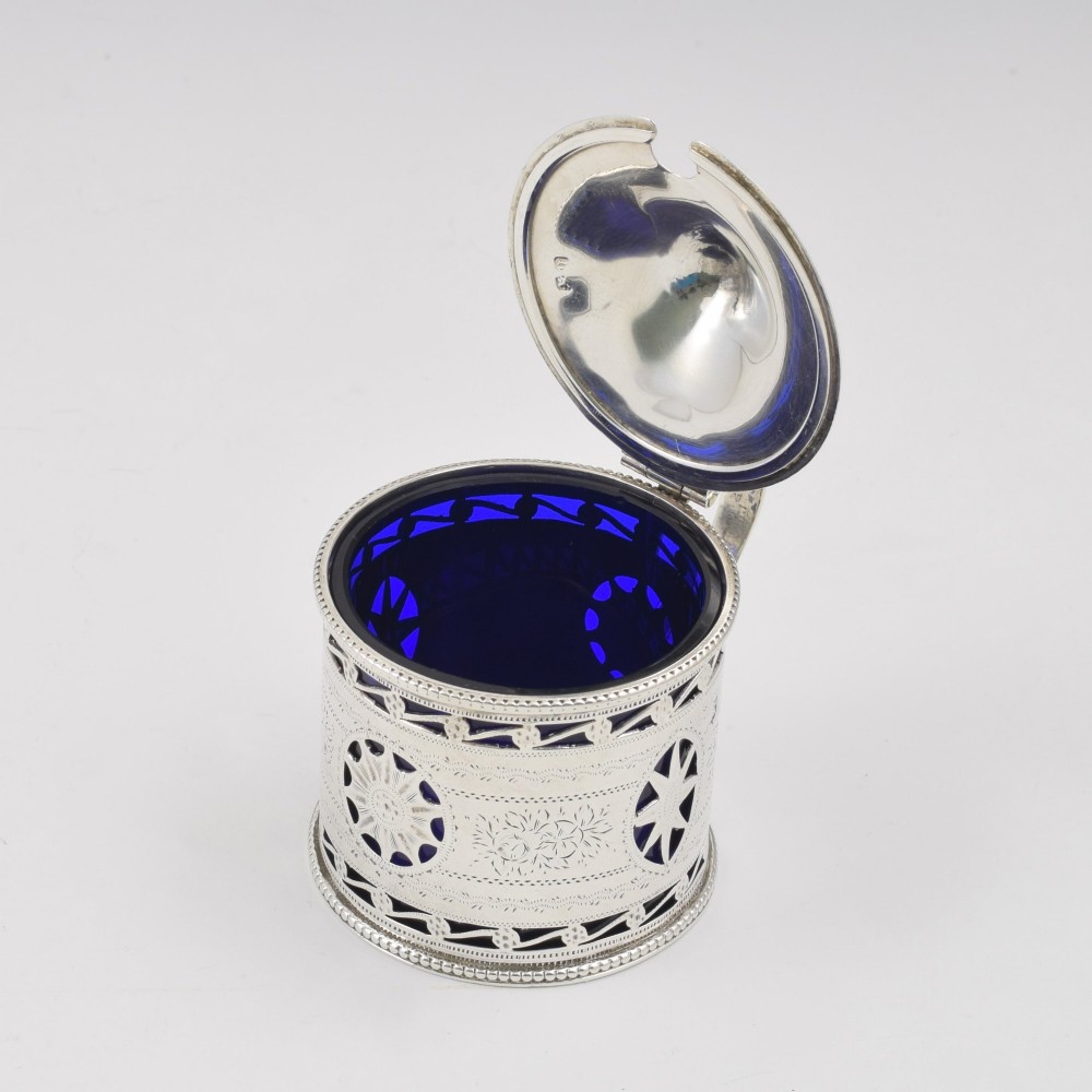 A Victorian silver drum mustard pot with pierced fretwork, bright-cut engraving, a hinged lid, and a cobalt blue glass liner. View VIII