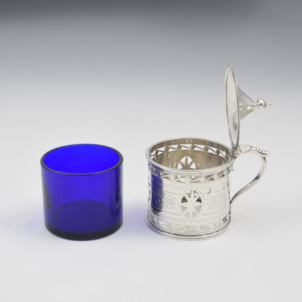 A Victorian silver drum mustard pot with pierced fretwork, bright-cut engraving, a hinged lid, and a cobalt blue glass liner. View IX