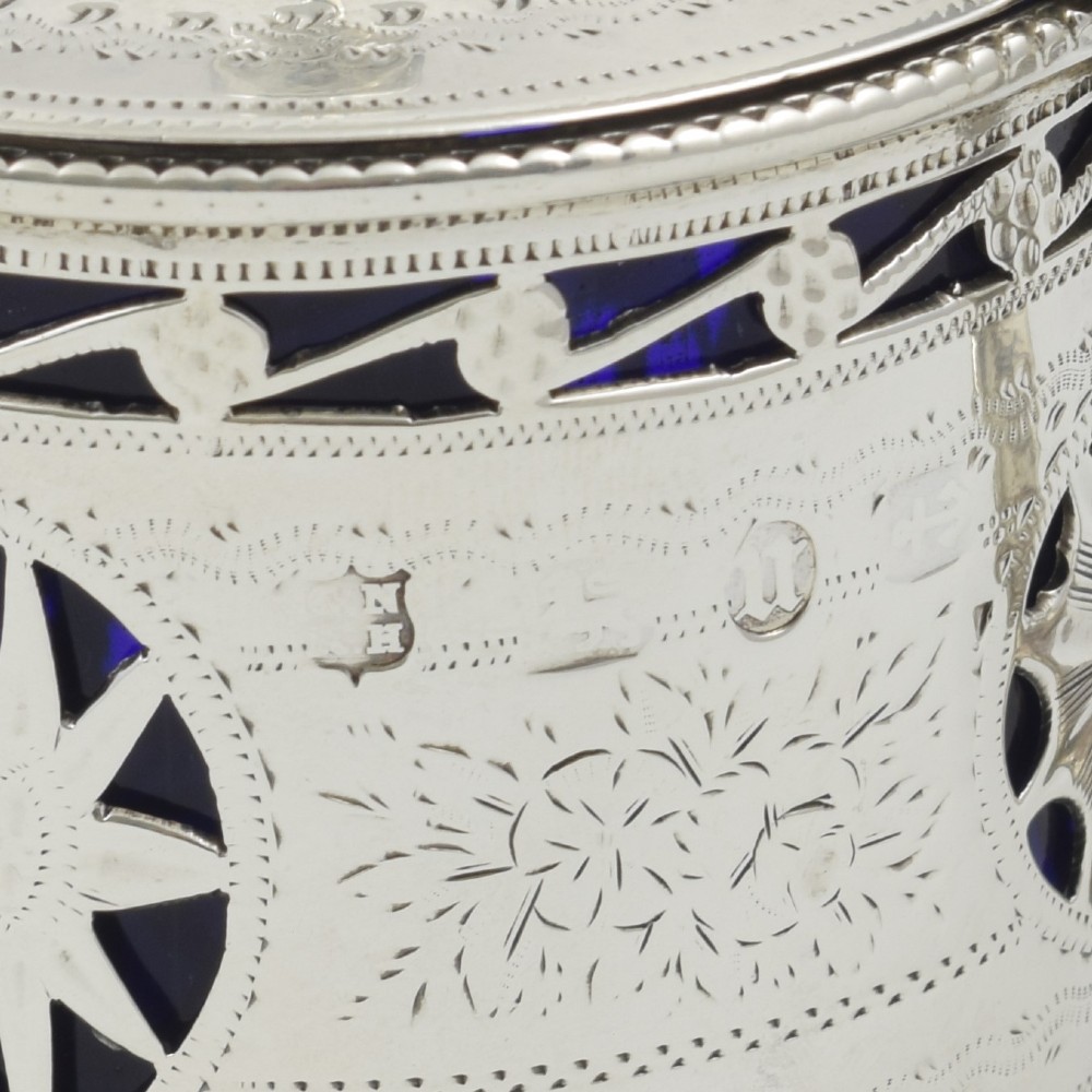 A Victorian silver drum mustard pot with pierced fretwork, bright-cut engraving, a hinged lid, and a cobalt blue glass liner. View X