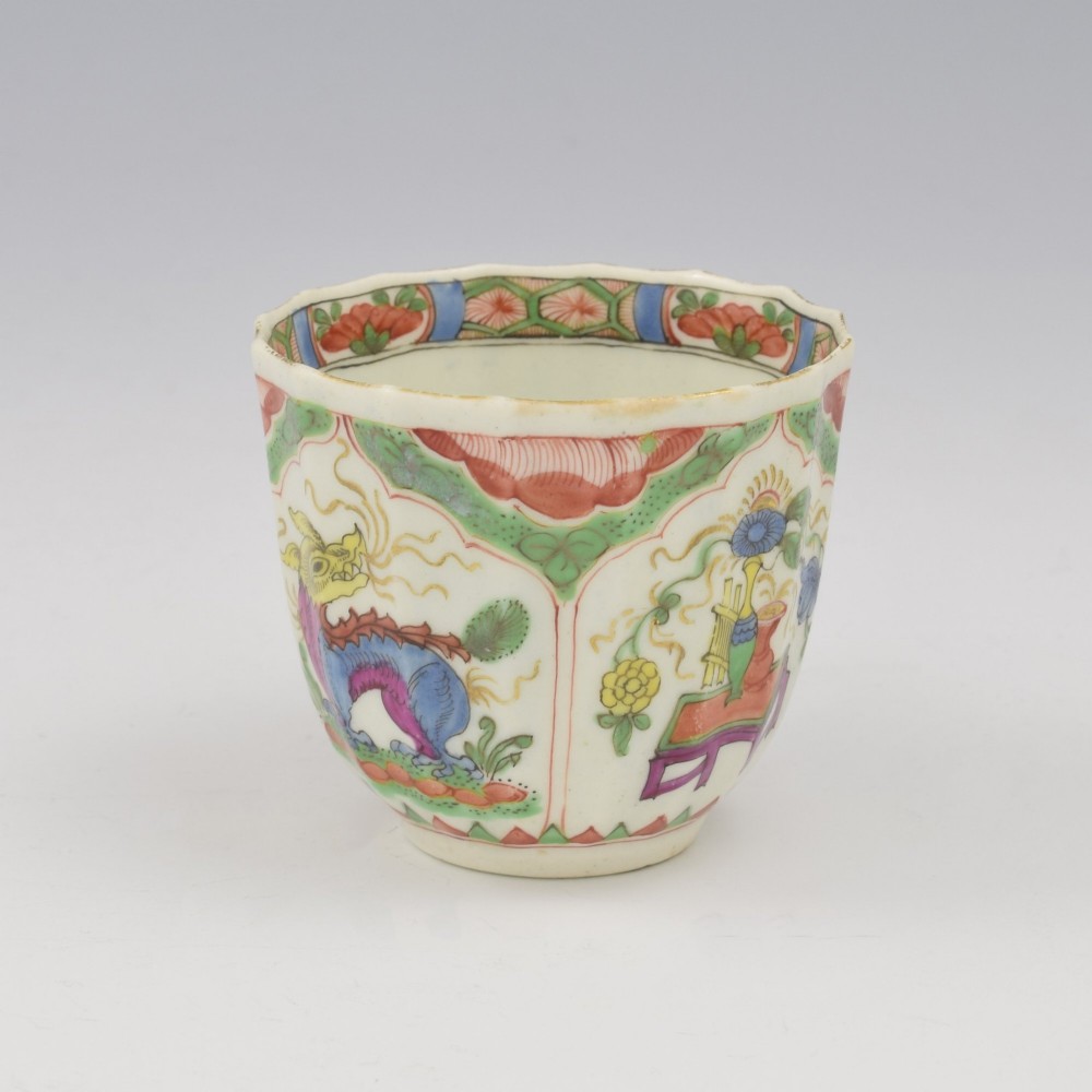 An 18th-century fluted soft-paste porcelain coffee cup with hand-painted Chinoiserie dragon motifs and a looped handle. View II