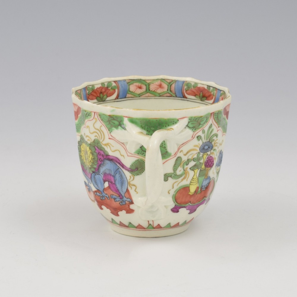 An 18th-century fluted soft-paste porcelain coffee cup with hand-painted Chinoiserie dragon motifs and a looped handle. View IV