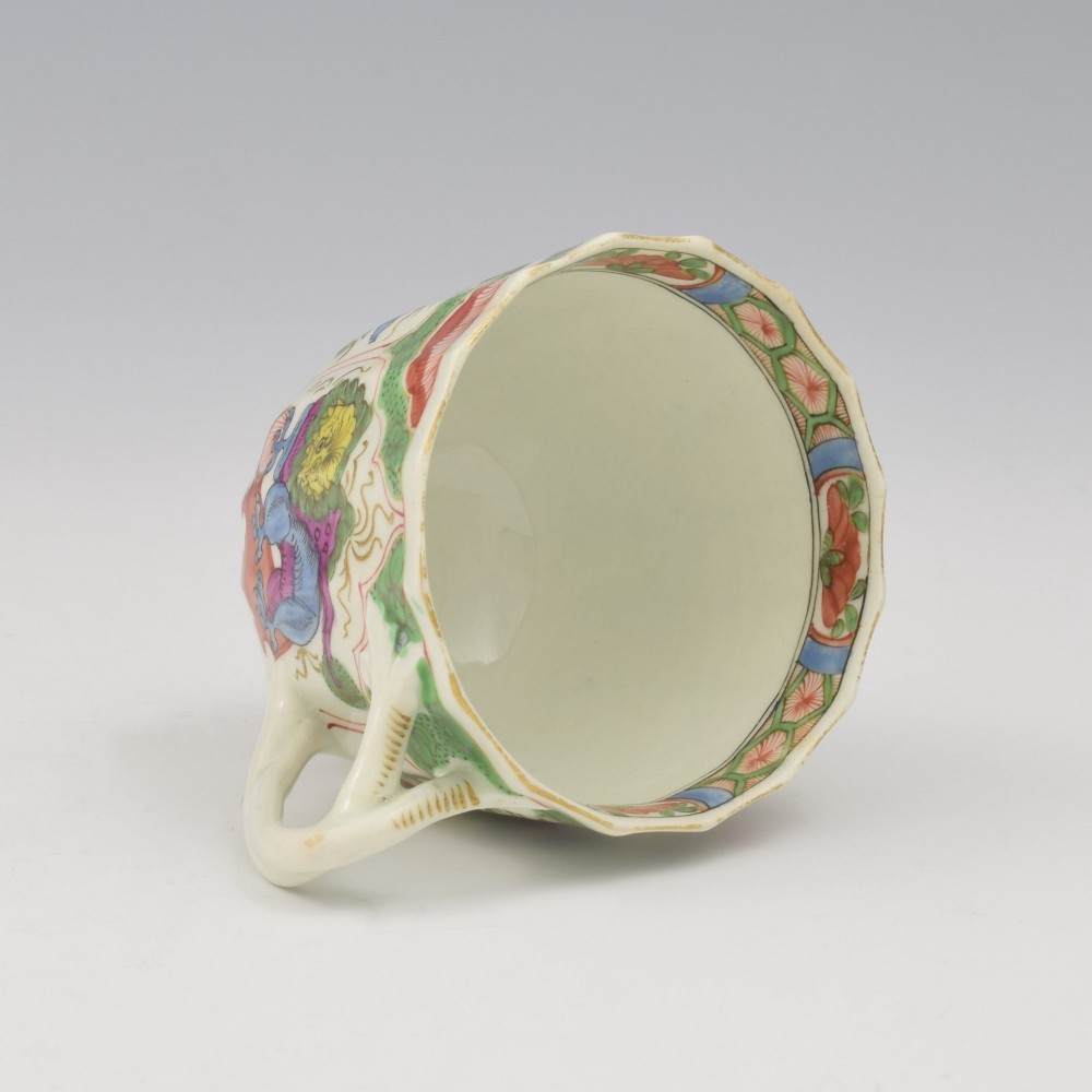 An 18th-century fluted soft-paste porcelain coffee cup with hand-painted Chinoiserie dragon motifs and a looped handle. View V