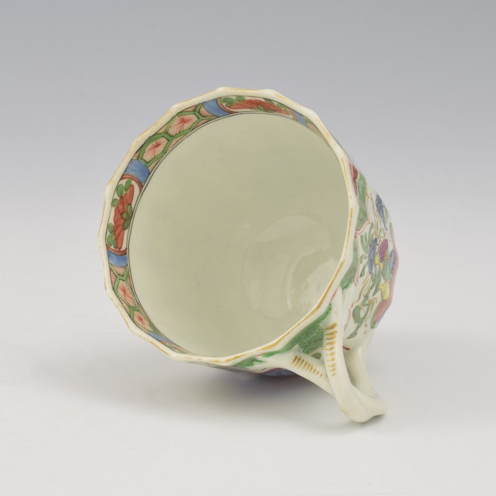An 18th-century fluted soft-paste porcelain coffee cup with hand-painted Chinoiserie dragon motifs and a looped handle. View VI