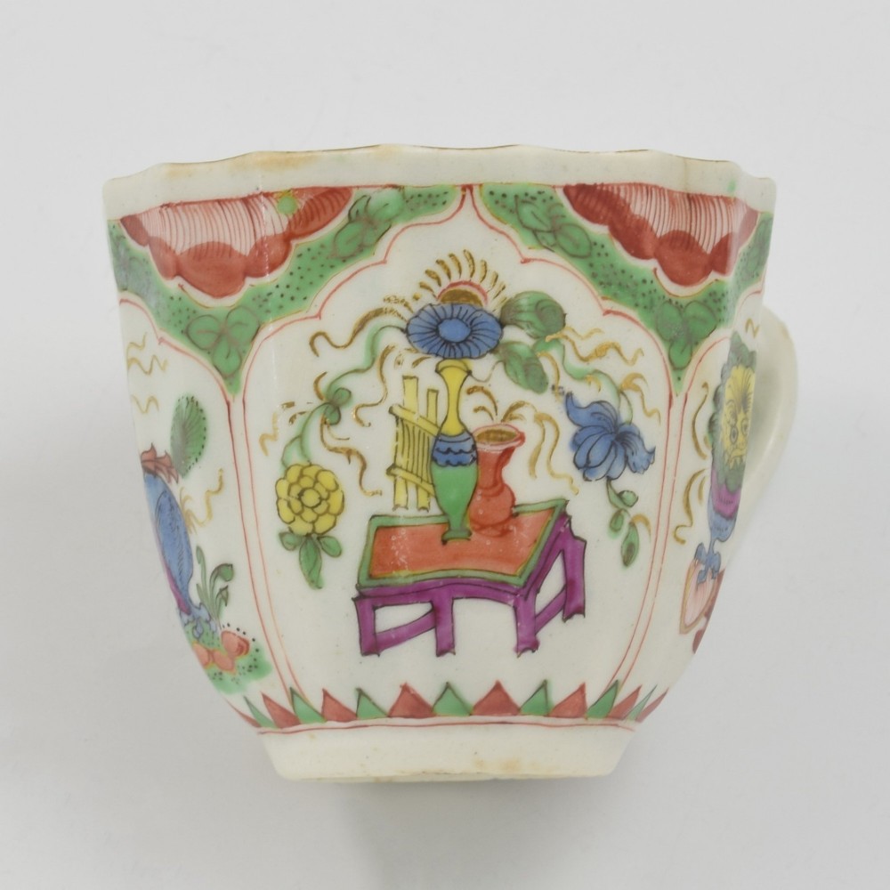 An 18th-century fluted soft-paste porcelain coffee cup with hand-painted Chinoiserie dragon motifs and a looped handle. View X